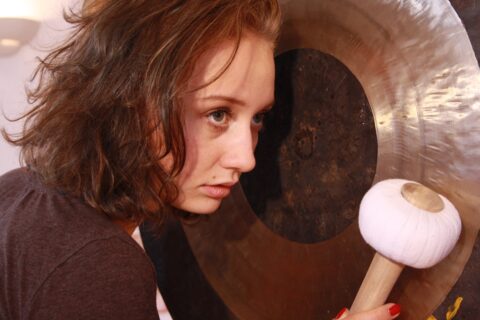 Anna-Lea spielt den Gong bei der 5 Elemente Klangmassage Ausbildung auf Grundlage der TCM in der Ausbildungsakademie TAO Touch in Bayreuth
